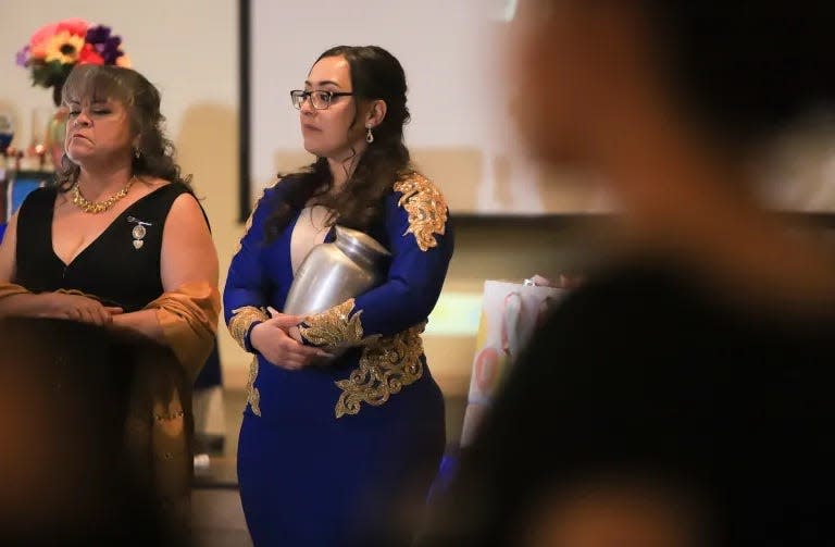 Jessica holds her husband’s urn while she watches Karina dance with her godfather and other relatives during her quinceañera celebration.
