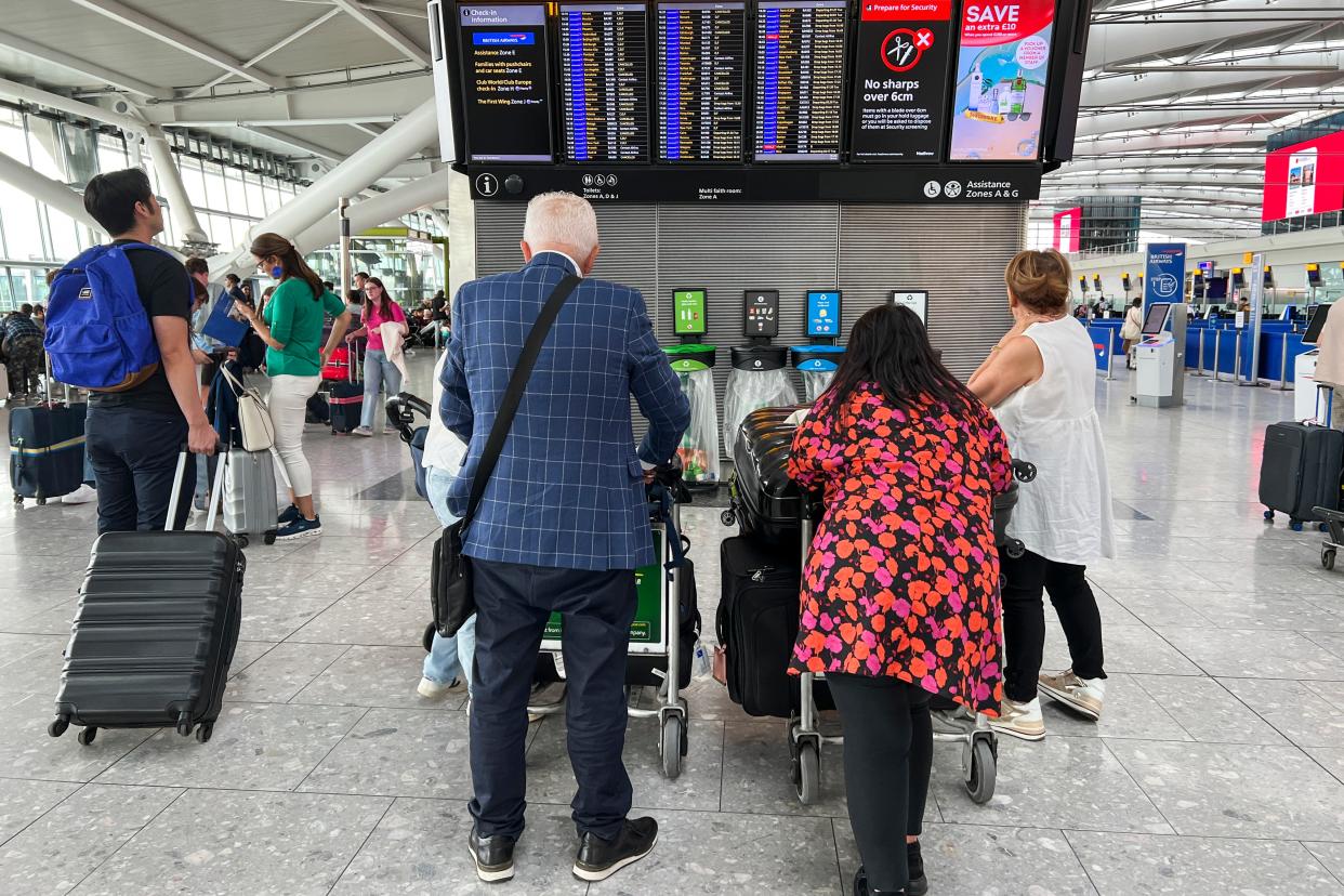 Passengers wait at a departure board at Heathrow for more information (Copyright 2023 The Associated Press. All rights reserved)