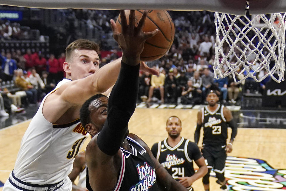 Denver Nuggets forward Vlatko Cancar, left, blocks the shot of Los Angeles Clippers guard John Wall during the second half of an NBA basketball game Friday, Nov. 25, 2022, in Los Angeles. (AP Photo/Mark J. Terrill)