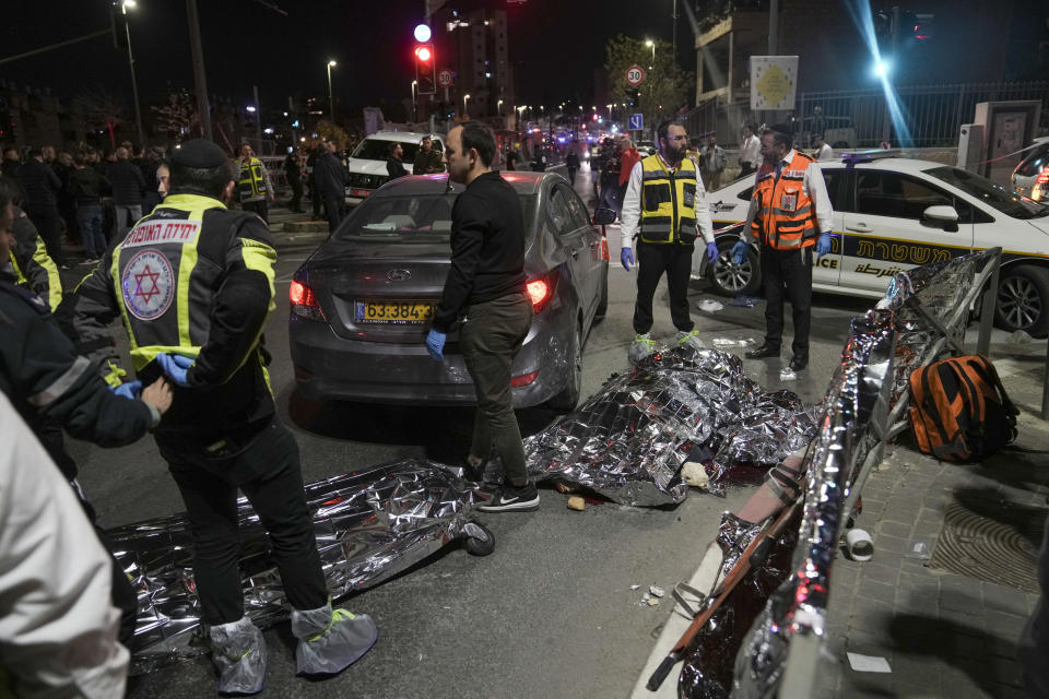 Victims of a shooting attack are covered on the ground near a synagogue in Jerusalem , Friday, Jan. 27, 2023. Israel's national rescue service Mada says a gunman killed five people and wounded three others in a shooting near a synagogue Friday night in east Jerusalem in one of the deadliest attacks on Israelis in years. The gunman was shot and reportedly killed. (AP Photo/Mahmoud Illean)