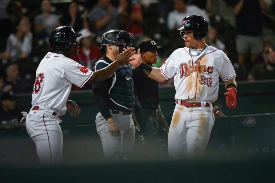 The Greenville Drive's Gilberto Jimenez (28) and Nick Decker (36) celebrate scoring two runs against Hudson Valley during the South Atlantic League championships at Flour Field in Greenville, S.C., on Tuesday, Sept. 19, 2023.