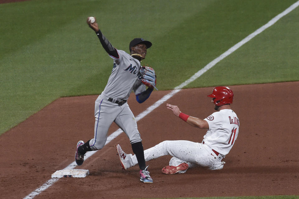 St. Louis Cardinals' Paul DeJong, right, is out at third as Miami Marlins shortstop Jazz Chisholm Jr. throws out Adam Wainwright at first during the eighth inning of a baseball game Tuesday, June 15, 2021, in St. Louis. (AP Photo/Joe Puetz)