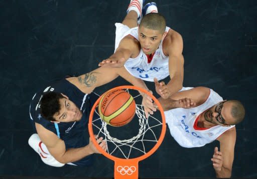 El jugador argentino Carlos Delfino (I) lucha por un rebote con los franceses Nicolas Batum y Tony Parker (D), este martes en Londres. La Francia de Tony Parker se impuso este martes 71-64 a la Argentina de su compañero Emanuel Ginóbili en la segunda jornada del torneo de baloncesto de los Juegos Olímpicos de Londres, que vio el primer enfrentamiento entre las dos estrellas de los San Antonio Spurs. (AFP | antonin thuillier)