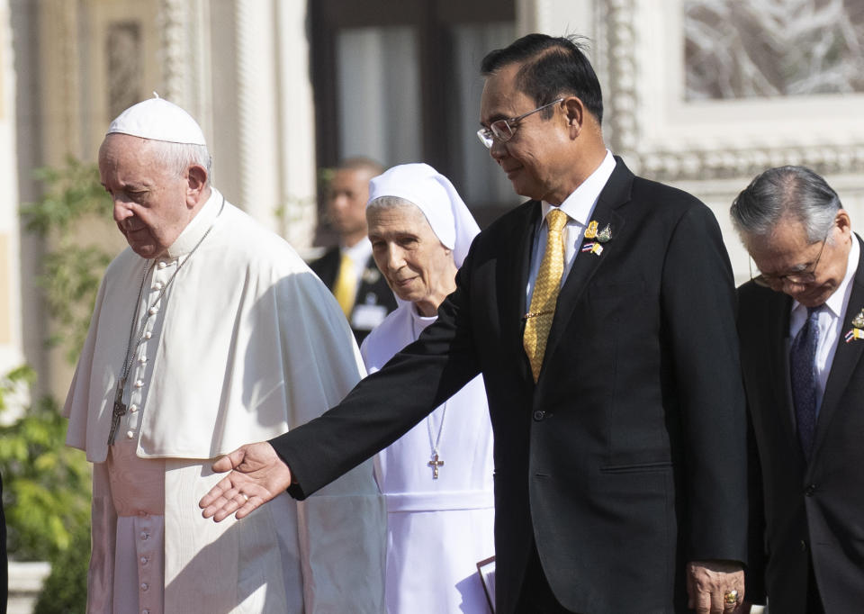 Pope Francis, left, walks with his cousin Ana Rosa Sivori, center, as Thailand's Prime Minister Prayuth Chan-ocha shows the way during a welcoming ceremony at the government house in Bangkok, Thailand, Thursday, Nov. 21, 2019. Pope Francis is on a four-day visit to Thailand. (AP Photo/Sakchai Lalit)