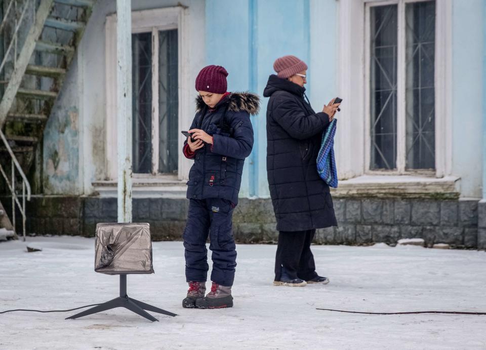 烏克蘭東部頓內茨克地區的民眾，在一座星鏈終端機旁連線上網。路透社