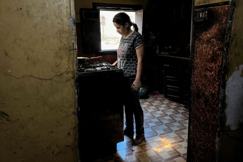 Mary Magdy, a Coptic Christian woman, cooks her lunch, in Cairo