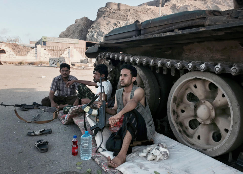 In this file photo taken Saturday, March 21, 2015, members of a militia group loyal to Yemen's President Abed Rabbo Mansour Hadi, known as the Popular Committees, chew qat, Yemen's favorite drug, as they sit next to their tank, guarding a major intersection in Aden, Yemen. The United Arab Emirates, one of the most powerful parties in Yemen’s war, has begun to draw down its forces in past weeks in 2019, leaving the Saudi-led coalition with a weakened ground presence and fewer tactical options. The withdrawal of several thousand troops comes amid heightened tensions between the United States and Iran, and as the Iranian-allied Yemeni rebels known as Houthis increase their attacks on Saudi Arabia.(AP Photo/Hamza Hendawi, File)