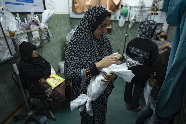 Palestinos lloran a sus familiares muertos en el bombardeo israelí de la Franja de Gaza, en el hospital de Rafah, en el sur de Gaza. (AP Photo/Fatima Shbair)