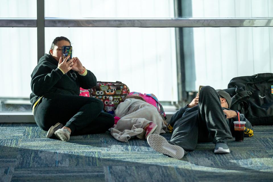 The Jurich family lays on the ground waiting for their flight at Will Rogers World Airport in Oklahoma City after the FAA had a computer outage grounding flights nationwide on Wednesday, Jan. 11, 2023.