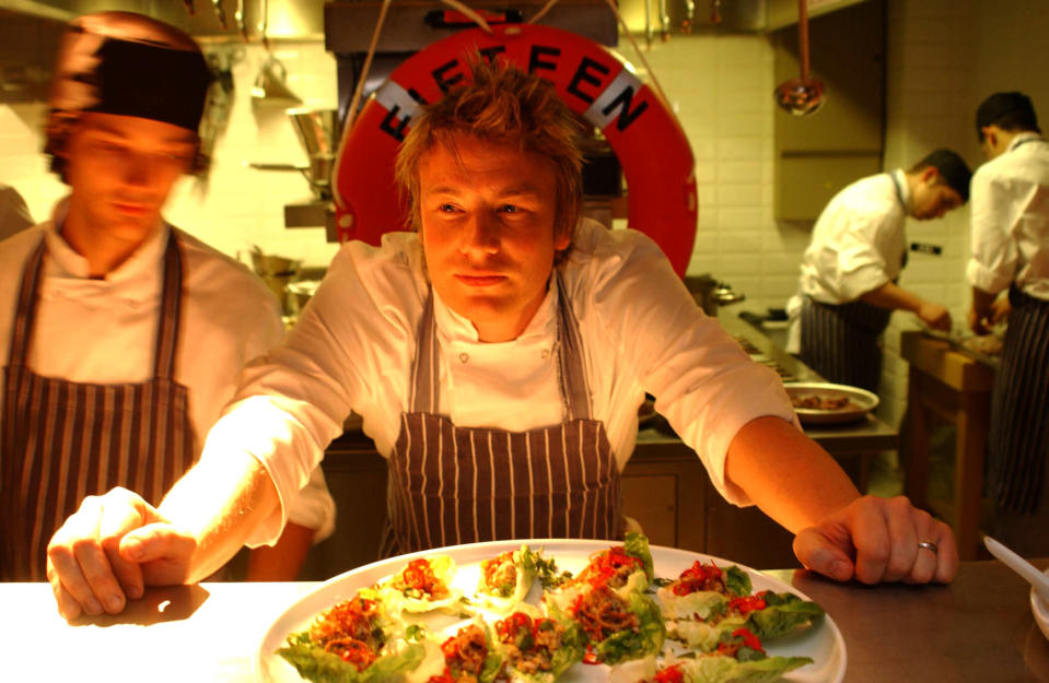 File photo dated 07/11/02 of chef Jamie Oliver in the kitchen during the launch of his restaurant 'Fifteen' in London's Old Street. Jamie Oliver's restaurant group, which includes Jamie's Italian, Barbecoa and Fifteen, has appointed administrators putting more than 1,300 jobs at risk.