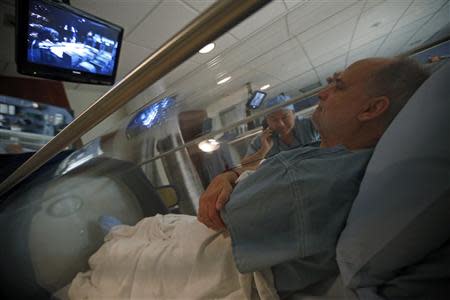 Doctor Andy Chiou speaks to patient Carl Dolson in a hyperbaric chamber in Peoria, Illinois, November 26, 2013. REUTERS/Jim Young