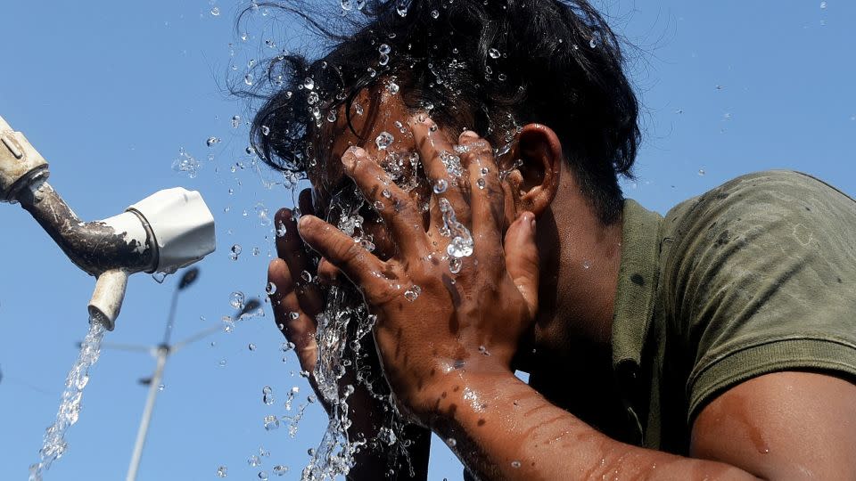 Un trabajador se salpica agua en la cara durante una ola de calor en Mumbai, India, el 22 de abril. - Indranil Aditya/NurPhoto vía Getty Images