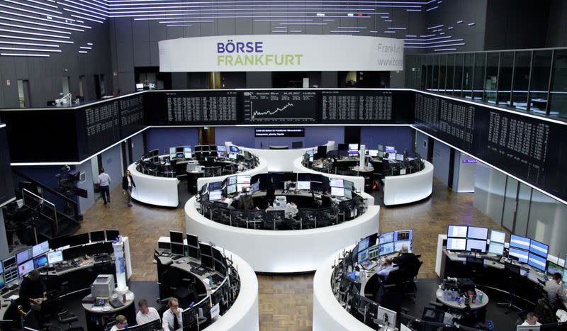 Traders work in front of the German share price index, DAX board, at the stock exchange in Frankfurt