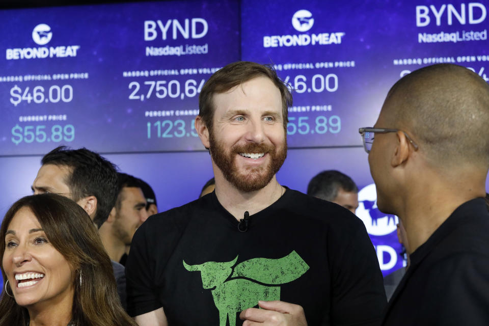 FILE - In this May 2, 2019, file photo Beyond Meat CEO Ethan Brown, center, watches as his company's stock begins to trade following its IPO at Nasdaq in New York. Plant-based meat maker Beyond Meat beat Wall Street’s expectations in its first earnings report since its IPO last month. The El Segundo, California-based company lost $6.6 million, or 95 cents per share, in the first quarter, up slightly from a 98-cent loss in the same period a year ago. (AP Photo/Mark Lennihan, File)