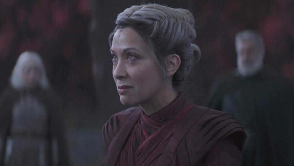 Morgan Elsbeth looks stern in red against a gold background on Ahsoka, Morgan Elsbeth is one of Star Wars Nightsisters of Dathomir. 