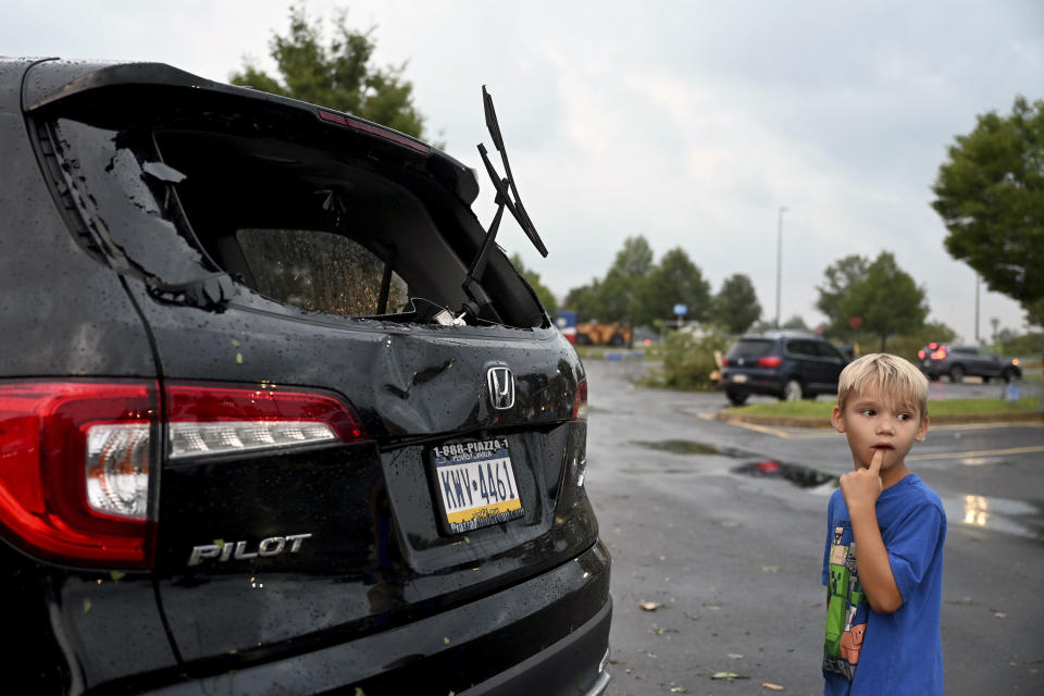 Storm damage to car is seen in a parking lot at the Walmart and Lowe's in Trevose, Pa. Thursday, July 29, 2021. Five people were injured Thursday when a building at a Bensalem auto dealership was destroyed by severe weather, authorities said. The National Weather Service confirmed two tornados touched down in Bucks County, sending trees falling and debris flying.(Tom Gralish/The Philadelphia Inquirer via AP)