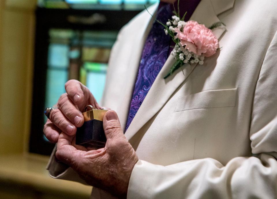 Bob Harvey dressed in a white sport coat with a pink carnation, pulls the wedding rings out before marrying Annette Callahan on Saturday, Oct. 19, 2019, in Westerville, Ohio.