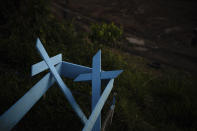 FILE - In this May 16, 2020, file photo, painted wooden crosses lie on the roadside of a new section of the Nossa Senhora Aparecida cemetery in Manaus, Brazil. Even amid a global pandemic, there’s no sign that corruption is slowing down in Latin America. In Brazil, which has the world's second-highest number of confirmed cases, police created a task force to investigate crimes tied to the pandemic. (AP Photo/Felipe Dana, File)