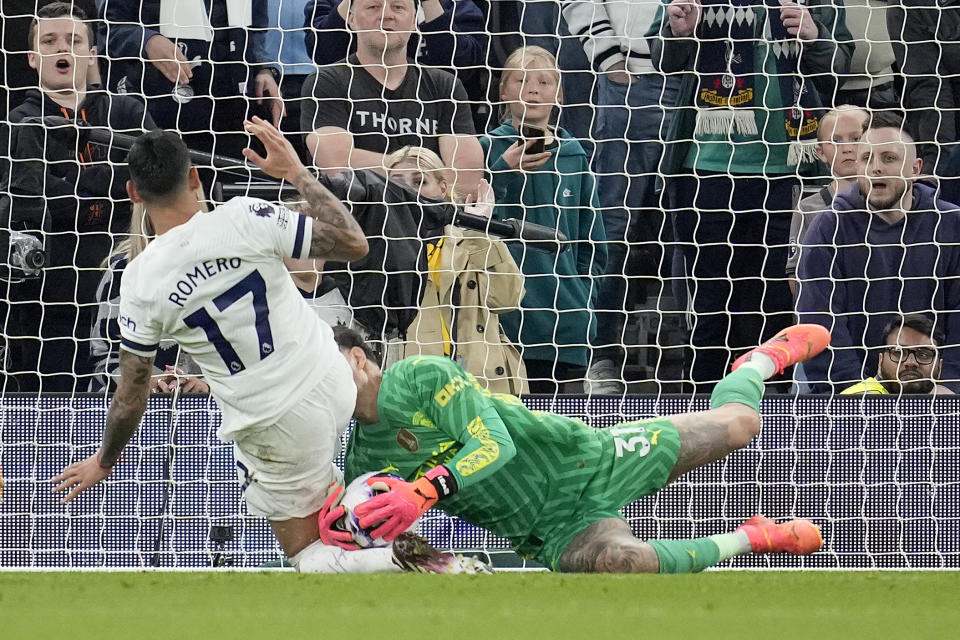 Tottenham's Cristian Romero, left, and Manchester City's goalkeeper Ederson challenge for the ball during the English Premier League soccer match between Tottenham Hotspur and Manchester City at Tottenham Hotspur Stadium in London, Tuesday, May 14, 2024.(AP Photo/Kin Cheung)