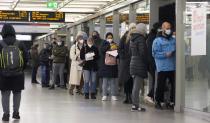 People line up at a vaccination center to get vaccinated against the coronavirus in a subway station in Duesseldorf, Germany, Monday, Dec. 6, 2021. (AP Photo/Martin Meissner)