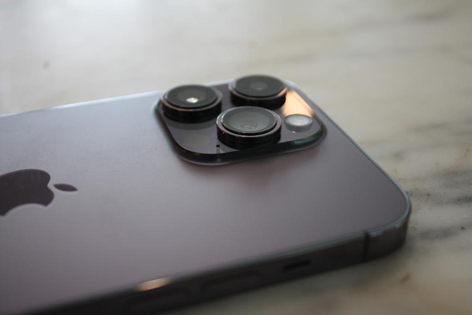 The new iPhone Pro phone on its back, showing the camera lenses