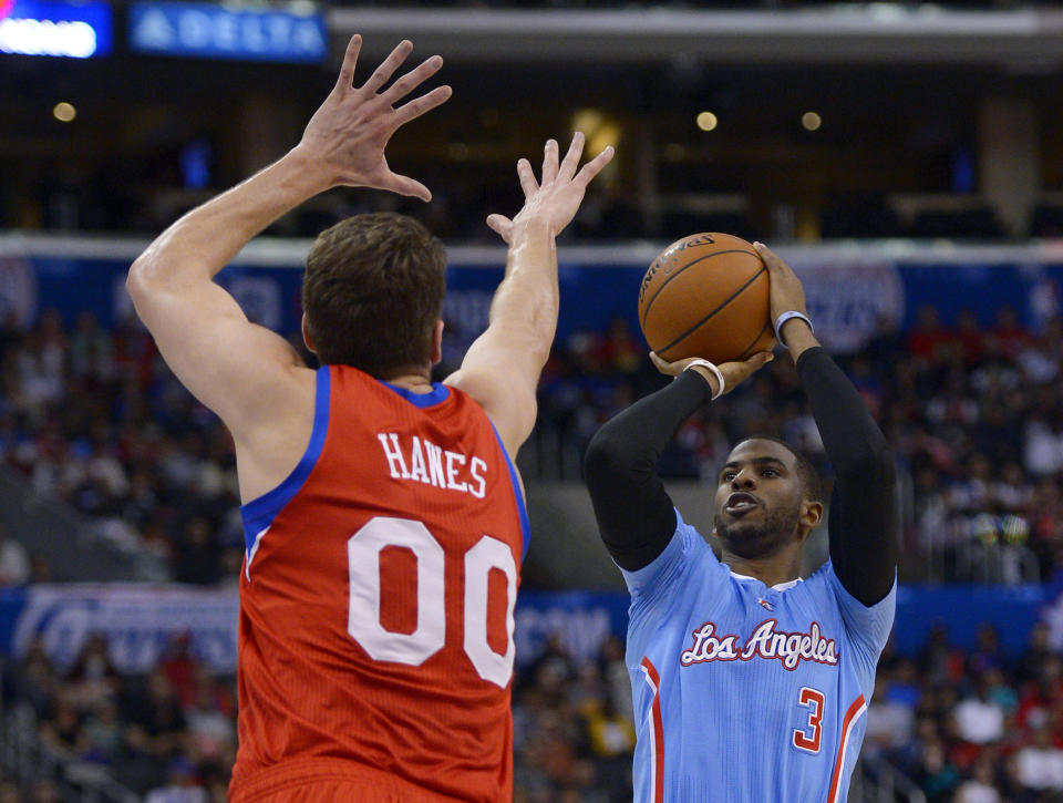 Los Angeles Clippers guard Chris Paul, right, puts up a shot as Philadelphia 76ers center Spencer Hawes defends during the first half of an NBA basketball game Sunday, Feb. 9, 2014, in Los Angeles. (AP Photo/Mark J. Terrill)