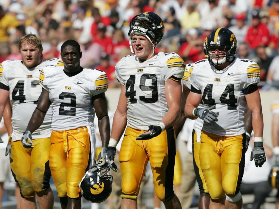 Former University of Iowa defenders Mitch King (left) Harold Dalton (2), A. J. Edds (49) and Mike Humpal (44) return to field after timeout during a game in September 2007.