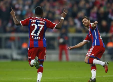 Bayern Munich's David Alaba celebrates his free-kick goal with fellow team mate Xabi Alonso (R) against Eintracht Braunschweig during their German Cup (DFB Pokal) soccer match in Munich March 4, 2015. REUTERS/Michael Dalder