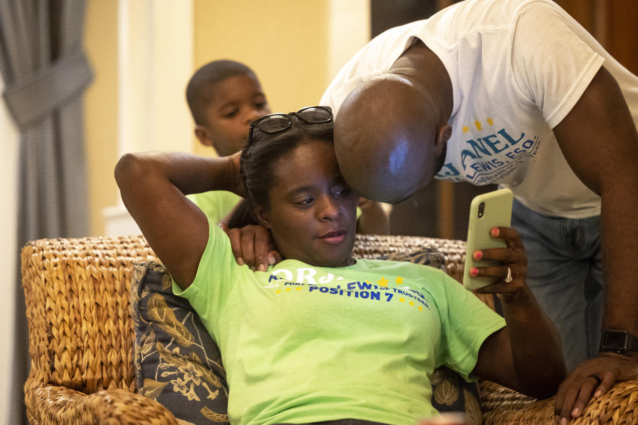 School board trustee hopeful Orjanel Lewis gets a hug from her husband, Marcus, as she looks for refreshed numbers  at her results watch party on May 7, 2022, in Fresno, Texas. (Annie Mulligan for NBC News)