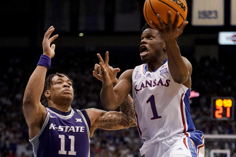 Kansas guard Joseph Yesufu (1) puts up a shot under pressure from Kansas State forward Keyontae Johnson (11) during the first half of an NCAA college basketball game Tuesday, Jan. 31, 2023, in Lawrence, Kan. (AP Photo/Charlie Riedel)