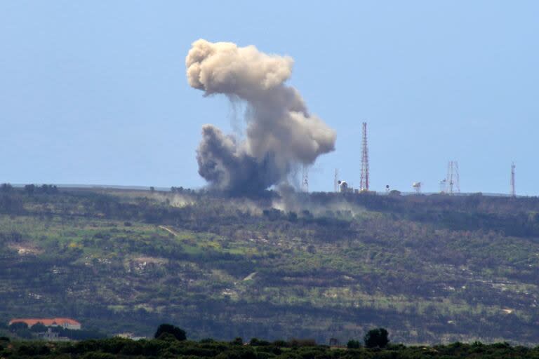 Una fotografía tomada desde la aldea de Alma al-Shaab, en el sur del Líbano, muestra humo elevándose desde un puesto de avanzada israelí después de un ataque con cohetes por parte de combatientes del movimiento Hezbollah del Líbano. (Photo by KAWNAT HAJU / AFP)