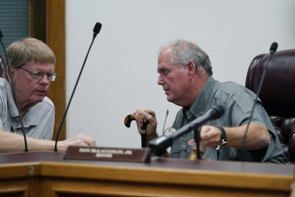 Uvalde Mayor Don McLaughlin, Jr., right, talks with council member Stephen Balke, left, during a special emergency city council meeting to reissue the mayor's declaration of local state of disaster due to the recent school shooting at Robb Elementary School, Tuesday, June 7, 2022, in Uvalde, Texas. Two teachers and 19 students were killed. (AP Photo/Eric Gay)