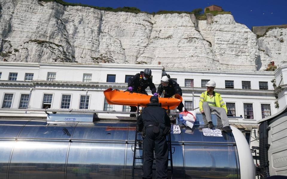 Police officers lift a protester from the top of a tanker, as Insulate Britain block the A20 in Kent - Gareth Fuller /PA