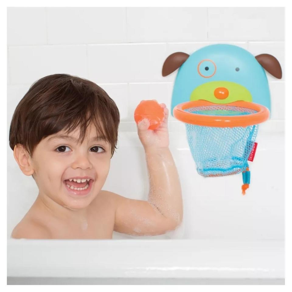 child playing with bath-sized hoop and orange basketball toys