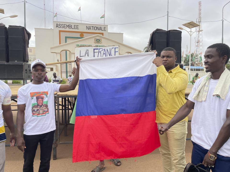 Supporters or Niger's ruling junta hold a Russian flag at the start of a protest called to fight for the country's freedom and push back against foreign interference in Niamey, Niger, Thursday, Aug. 3, 2023. The march falls on the West African nation's independence day from its former colonial ruler, France, and as anti-French sentiment spikes, more than one week after mutinous soldiers ousted the country's democratically elected president. (AP Photo/Sam Mednick)
