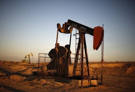 Pump Jacks are seen at sunrise near Bakersfield, California October 14, 2014. REUTERS/Lucy Nicholson/Files