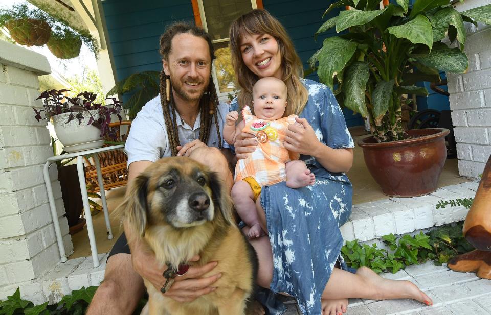 Cody Frennea, Kristi Ray, River Ray Frennea and their dog Kaya outside of their home in Sunset Park.