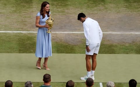 Djokovic gets ready to receive the trophy from the Duchess of Cambridge - Credit: AFP