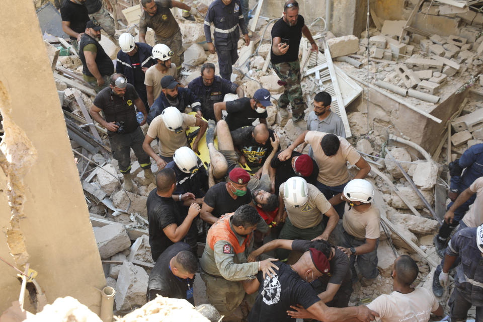 FILE - In this Wednesday, Aug. 5, 2020 file photo, a survivor is taken out of the rubble after a massive explosion in Beirut, Lebanon. It was 20 minutes before 6:08 p.m. when the Beirut fire brigade received the call from an employee at the nearby port reporting a big fire. Ten firefighters, including a female paramedic, piled into a fire engine and an ambulance and raced toward the scene, and their ultimate death. (AP Photo/Hassan Ammar, File)