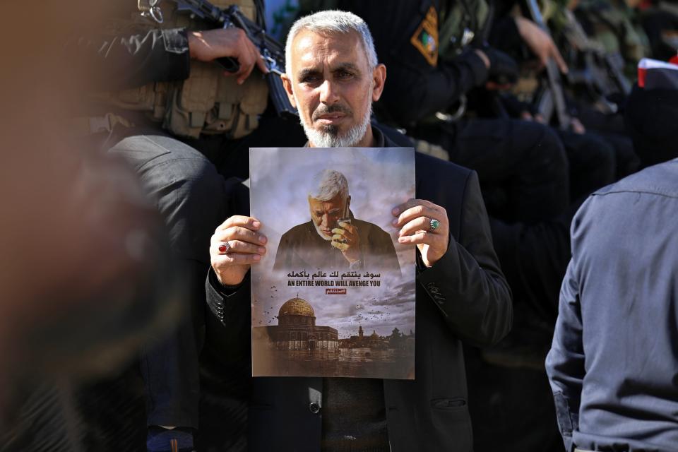 Mourners gather during a funeral procession for Abu Mahdi al-Muhandis, in the poster, deputy commander of Iran-backed militias in Basra, Iraq, Tuesday, Jan. 7, 2020. Thousands of people gathered in Basra on Tuesday to bid farewell to Abu Mahdi al-Muhandis, a senior Iraqi militia commander who was killed in a US airstrike on Friday. (AP Photo)