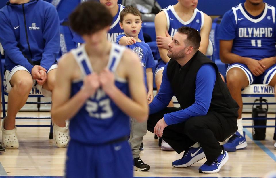 Olympic head coach Jon O'Connor answers a question from his son Mickey as his team lines up for a free throw during the Trojans' contest against Lakes on Jan. 21.