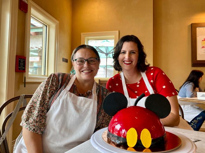 Author and friend posing behind Mickey-dome cake.