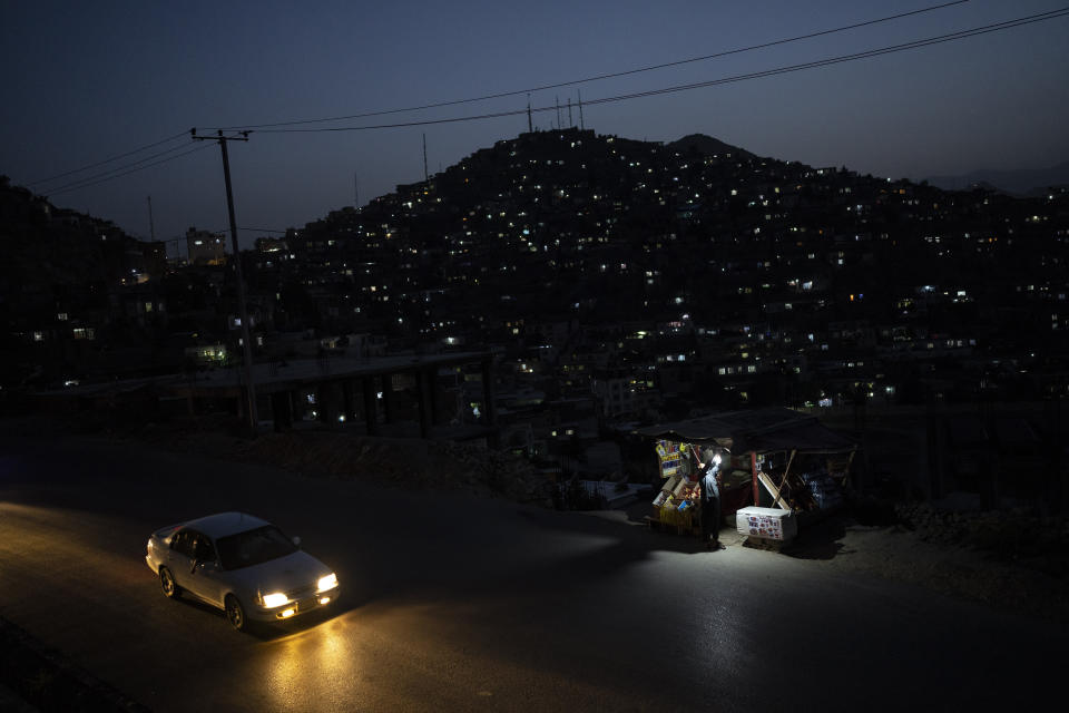 A man fixes a lamp in his shop in Kabul, Afghanistan, Monday, June 19, 2023. (AP Photo/Rodrigo Abd)