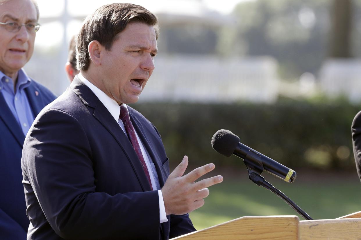 FILE- In this March 23, 2020 file photo, Florida Gov. Ron DeSantis delivers remarks during a press conference at a coronavirus mobile testing site in The Villages, Fla. The Villages, a retirement community, is one of the largest concentration of seniors in the U.S. Republican Gov. Ron DeSantis has been walking a tightrope for weeks during the coronavirus crisis, trying to protect both Floridians vulnerable to the virus and the cratering economy in a state of 21 million people.