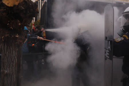 A protester uses a fire extinguisher against riot police during clashes outside the parliament building as Greek school teachers demonstrate against government plans to change hiring procedures in the public sector in Athens, Greece, January 14, 2019. REUTERS/Alkis Konstantinidis