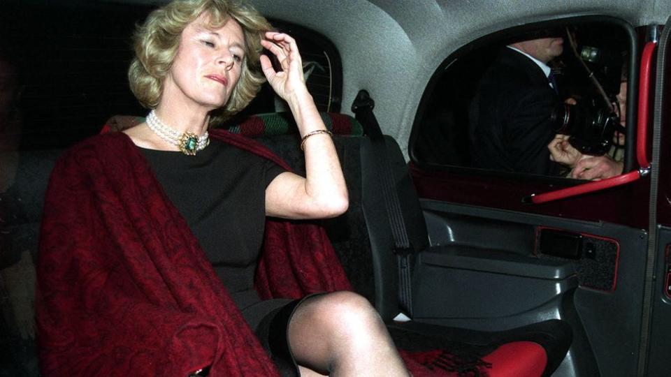 a person in a red dress sitting in a car