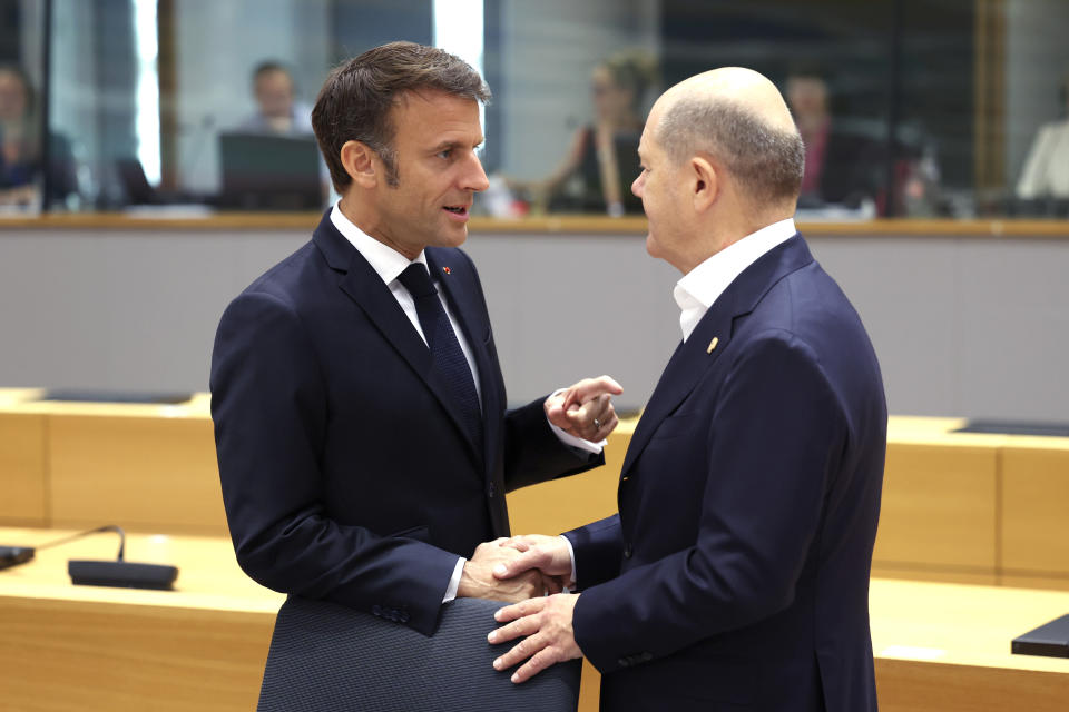 FILE - France's President Emmanuel Macron, left, speaks with Germany's Chancellor Olaf Scholz during a round table meeting at the European Council building in Brussels, Friday, June 30, 2023. After six years in power, French President Emmanuel Macron appears further weakened by days of rioting over the death of a teen killed by police that come on top of a series of other challenges at home, leading domestic politics to impede his influence abroad. Macron was forced to delay his state visit to Germany meant to show the strength of the friendship between both nations after recent disputes over on issues including energy, defense and the economy. (AP Photo/Geert Vanden Wijngaert, File)