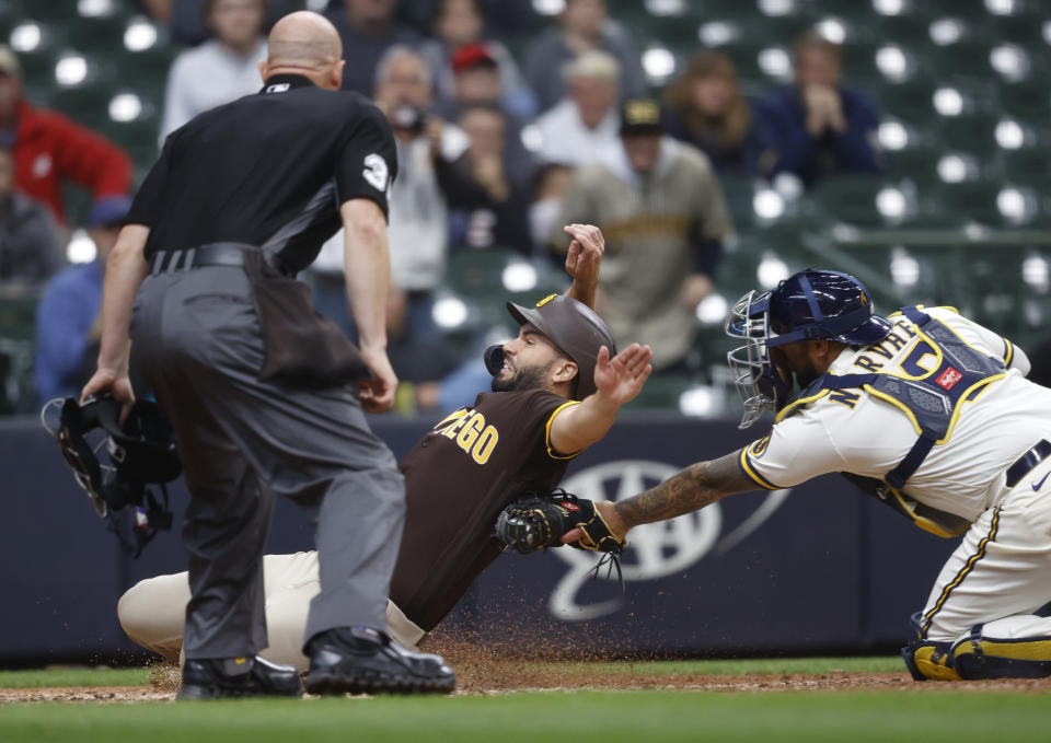 San Diego Padres first baseman Eric Hosmer (30) is tagged out by Milwaukee Brewers Milwaukee Brewers catcher Omar Narvaez (10) during the eighth inning of a baseball game Thursday, May 27, 2021, in Milwaukee. (AP Photo/Jeffrey Phelps)