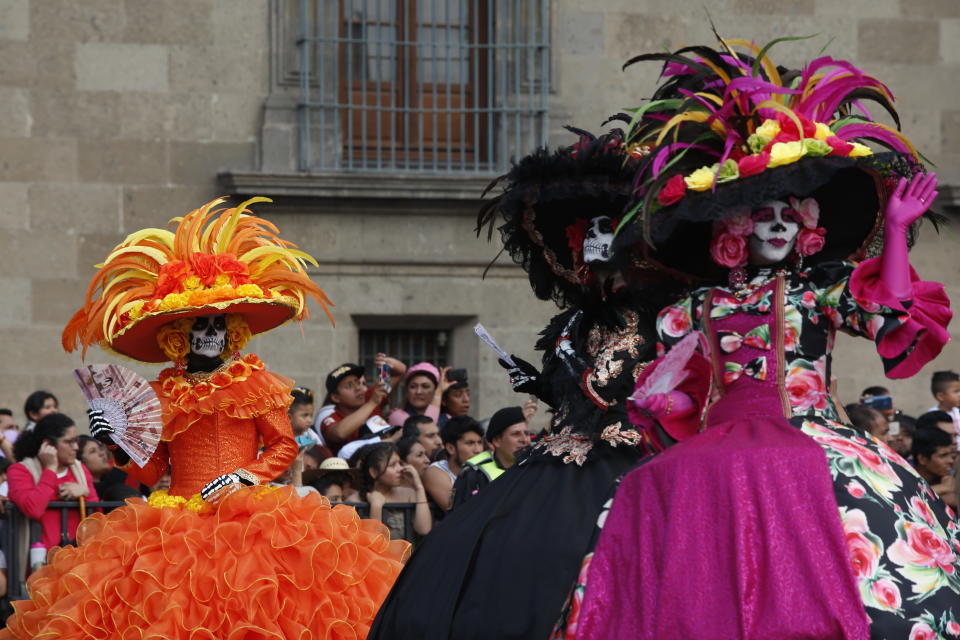 Performers in costume wave during the annual International Day of the Dead Parade in Mexico City, Sunday, Oct. 27, 2019. The idea for the parade, now in its fourth edition, came out of the imagination of a scriptwriter for James Bond's movie Spectre. (AP Photo/Ginnette Riquelme)