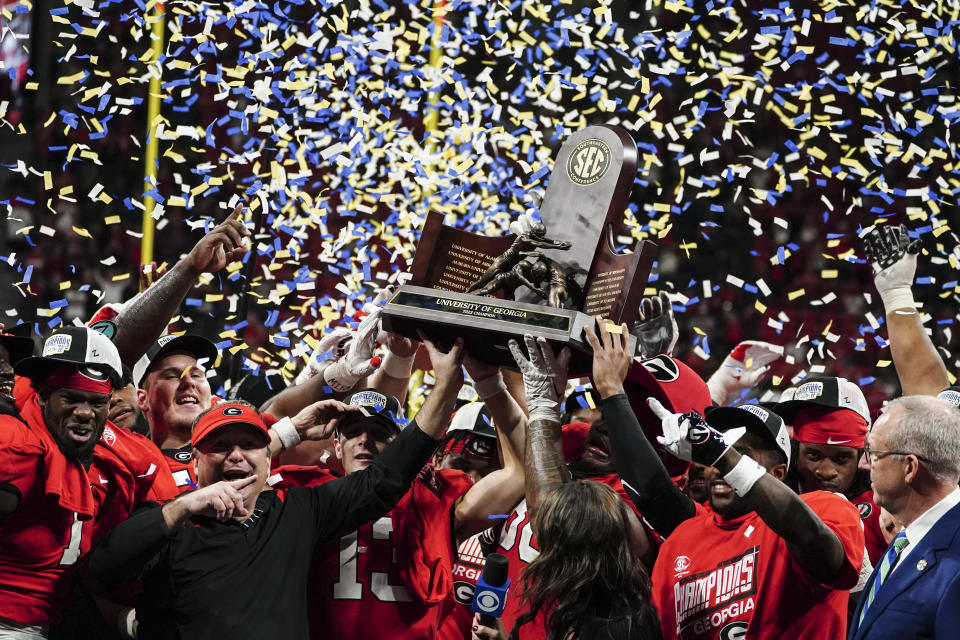 Georgia players hoist the trophy after defeating LSU in the Southeastern Conference Championship football game Saturday, Dec. 3, 2022 in Atlanta. (AP Photo/John Bazemore)
